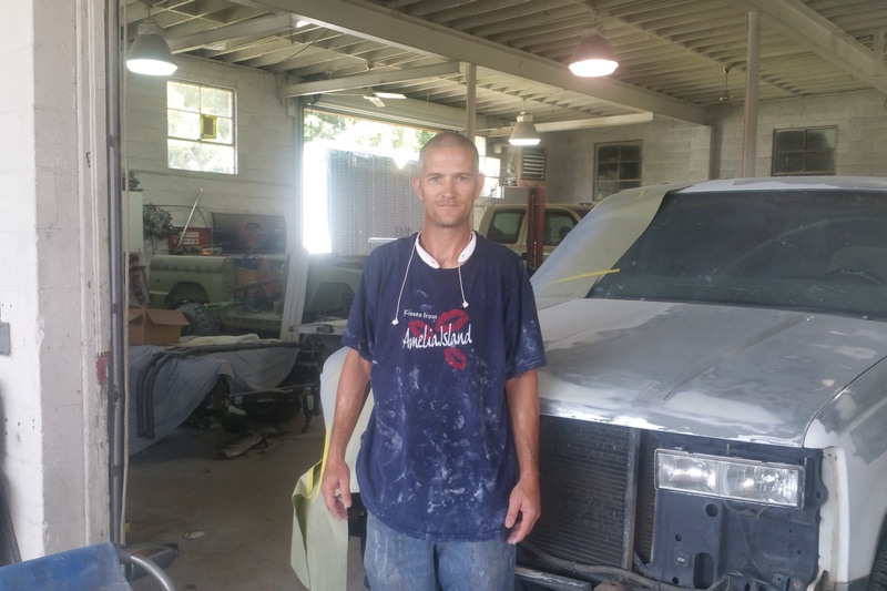 andy standing in front of truck at shop